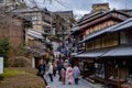 Traditional street in Gion surrounded by shops and people walking dressed in traditional costumes