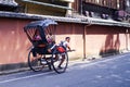 KYOTO, JAPAN 08.2019 Japanese rickshaw rides kimano-dressed girls Royalty Free Stock Photo