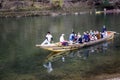 Kyoto, Japan, 04/06/2017: Japanese wooden boats with tourists on the water in spring blooming nature. Beautiful authentic Royalty Free Stock Photo