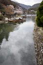 Kyoto, Japan, 04/05/2017: Japanese wooden boats with tourists on the water in spring blooming nature. Beautiful authentic Royalty Free Stock Photo