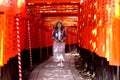 Teen girl post acting to take photo holy  torii line at Fushimi Inari Shrine Royalty Free Stock Photo