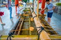 KYOTO, JAPAN - JULY 05, 2017: Unidentified people washing their hands at hand wash pavilion in Fushimi Inari Shrine in Royalty Free Stock Photo