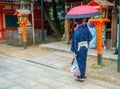 KYOTO, JAPAN - JULY 05, 2017: Young Japanese man wearing traditional Kimono and holding umbrellas in their hands in the Royalty Free Stock Photo