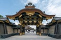 Kyoto, Japan - 05.30.2019: Look through the richly decorated gate of Nijo castle, Kyoto, Japan. People gathering in the courtyard