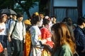 View of Geisha girls walking in crowd of people in sunny afternoon on small street