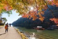 Unidentified tourists enjoy autumn colors along Hozu-gawa river at Arashiyama