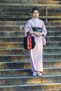 Beautiful and Serene Japanese Lady Posing in Geisha Kimono On Shrine Stairway in Kyoto Streets, Royalty Free Stock Photo