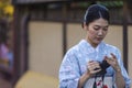 KYOTO, JAPAN - NOVEMBER, 8, 2019: Beautiful Tranquil Japanese Girl Posing in Geisha Kimono With Photocamera in Kyoto Streets, Royalty Free Stock Photo