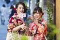 KYOTO, JAPAN - NOVEMBER, 8, 2019: Couple of  Young Japanese Girls Wearing Traditional Geisha`s Kimono Taking Photos On Kyoto Royalty Free Stock Photo