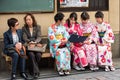 KYOTO, JAPAN - NOVEMBER 7, 2017: A group of girls in a kimono sit on a bench. Copy space for text.