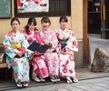 KYOTO, JAPAN - NOVEMBER 7, 2017: A group of girls in a kimono sit on a bench. Copy space for text.