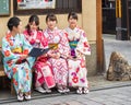 KYOTO, JAPAN - NOVEMBER 7, 2017: A group of girls in a kimono sit on a bench. Copy space for text.