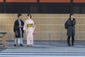 KYOTO, JAPAN - NOVEMBER, 8, 2019: Japanese Couple in Traditional Kimono Standing on Crosswalk With Other Pedestrians in Kyoto,