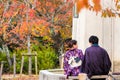 KYOTO, JAPAN - NOVEMBER 7, 2017: A loving couple in a kimono sits on a bench. Copy space for text.