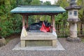 The statue of ox lying down near the stone lantern at Kitano Tenmangu shrine. Kyoto. Japan Royalty Free Stock Photo