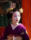 KYOTO, Japan. 08/11/2019. Real geisha geiko hosting an event at Yasaka Shrine, wearing purple kimono. Royalty Free Stock Photo