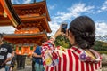 Kyoto, Japan - Sept 20th 2018 - A woman dressing like a geisha taking a picture of a temple in a sunny blue sky day in Kyoto,