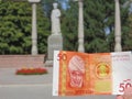 Kyrgyz banknote with Kurmanjan Datka on the background of her monument in Bishkek Royalty Free Stock Photo