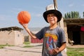 KYRGYZSTAN: Boy in national hat plays basketball Royalty Free Stock Photo