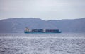 Kythnos Greek island. Container cargo ship in blue sea background