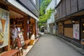 Local vintage street atmosphere with an unidentified man in ice cream shop and restaurant buildings, Kurokawa Onsen town Royalty Free Stock Photo