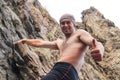 Kyzyl, Tuva - August 15, 2015: Young attractive sexy strong male athlete rock climber climbs on a rock. Strong muscular male