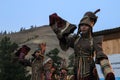 Mongolian woman in shaman and witch costume dances on stage in the mountains. Tyva folk dances