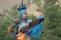 Mongolian woman in shaman and witch costume dances on stage in the mountains. Tyva folk dances