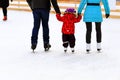 A l boy with dad and mom skates on the rink in the winter. Active family sport, winter holidays, sports clubs Royalty Free Stock Photo