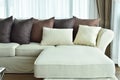 L shape beige sofa with varies brown pillows Royalty Free Stock Photo