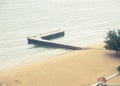 L shape concrete fishing pier with beach surf fishermen along sandy shoreline, calm waves at public park in downtown Nha Trang, Royalty Free Stock Photo