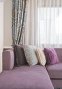 L shape purple sofa with stylish pillows in living room Royalty Free Stock Photo