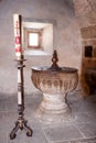 Baptismal font and baptism candle, Our Lady of the Assumption, La Alberca, Salamanca, Spain Royalty Free Stock Photo