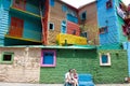 La Boca Buenos Aires, Couple sitting on bench between colorful walls and houses in Caminito
