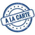 A LA CARTE text on blue grungy round rubber stamp