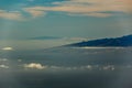 La Gomera and El Hierro islands, flying in the air between different clouds. Bright blue sky. View from 1900m of altitude. Teide