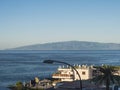 La Gomera Island east coast seen from Playa de la Arena at Tenerife. Long lens shot. Clear blue sky with clouds