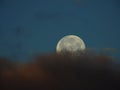 La luna de nieve semicubierta por nubes rojas