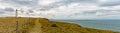 Panorama view of ocean and coast with green fields and jagged cliffs