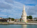 Sailing dinghies at the dock ready to sail with a tower in the background in La Rochelle