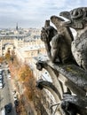 Two famous chimera statues of Notre-Dame de Paris cathedral, gazing at the city from the towers gallery