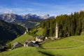 La Vale - Italian Dolomites, a small village in the mountains, right by a high forest stands a slender church, on the left on the Royalty Free Stock Photo