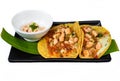 La Viga tacos with shrimps and mexican sauce on black plate isolated on white background