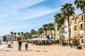 La Vila Joiosa, Spain- March 28, 2023: Beautiful promenade with colorful houses, people, outdoors cafe on sunny day in