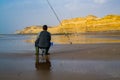 Laayoune, Morocco - 30 July 2022 : A Fisher man looking at his fisher rod Royalty Free Stock Photo