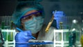 Lab assistant analyzing meat sample in preservative agent and writing results Royalty Free Stock Photo