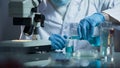 Lab assistant pouring liquid reagent into beaker to create chemical solution