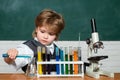 Lab microscope and testing tubes. Little kid scientist earning chemistry in school lab. Child in the class room with Royalty Free Stock Photo