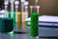 Lab table with test tubes of green plastic granules. Biodegradable plastic Royalty Free Stock Photo