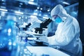 Lab technician analyzing biomaterial samples under microscope, observing cell structures